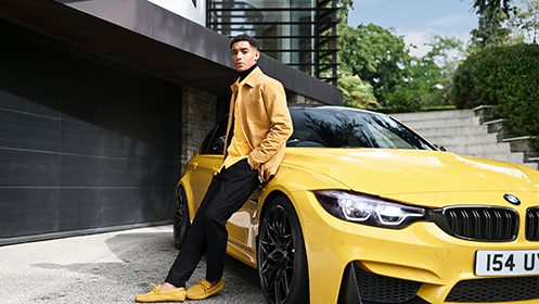 Man sitting against yellow BMW